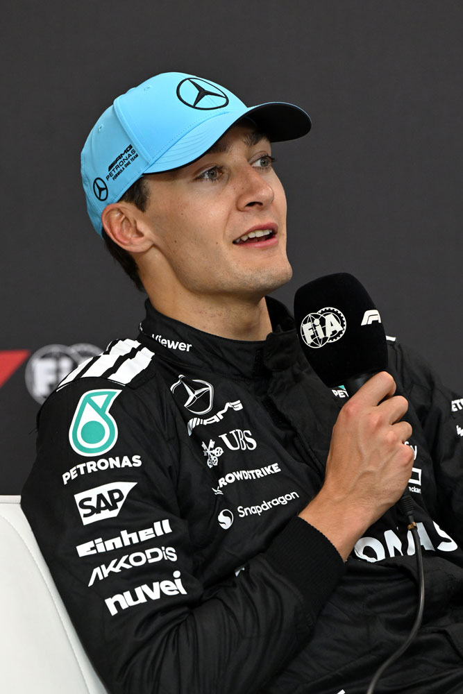 Οδηγός Formula 1, George Russell, με μικρόφωνο στο δεξί χέρι.