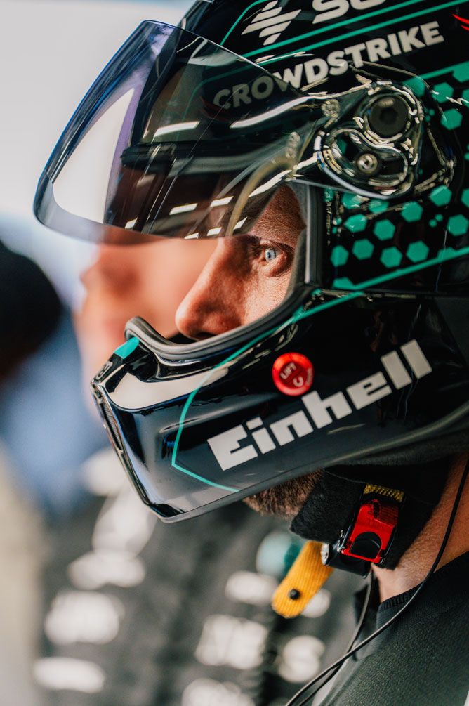 Μέλος του πληρώματος της Formula 1 φορά κράνος και κοιτάζει προσηλωμένα στο πλάι.
